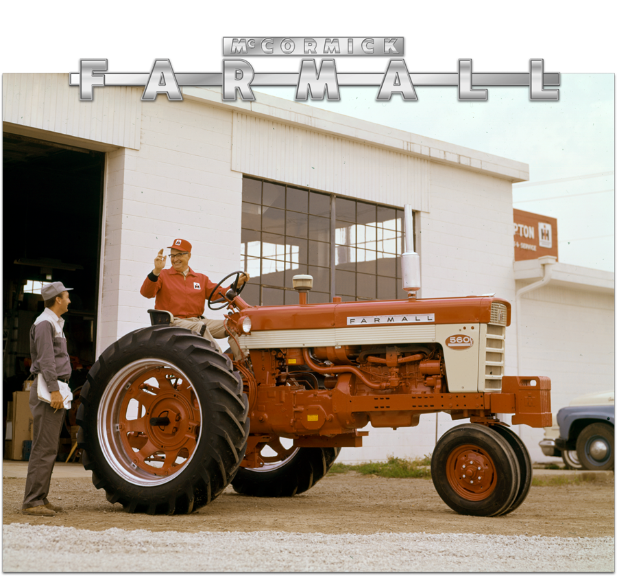 Two men talking while one sits on a Farmall