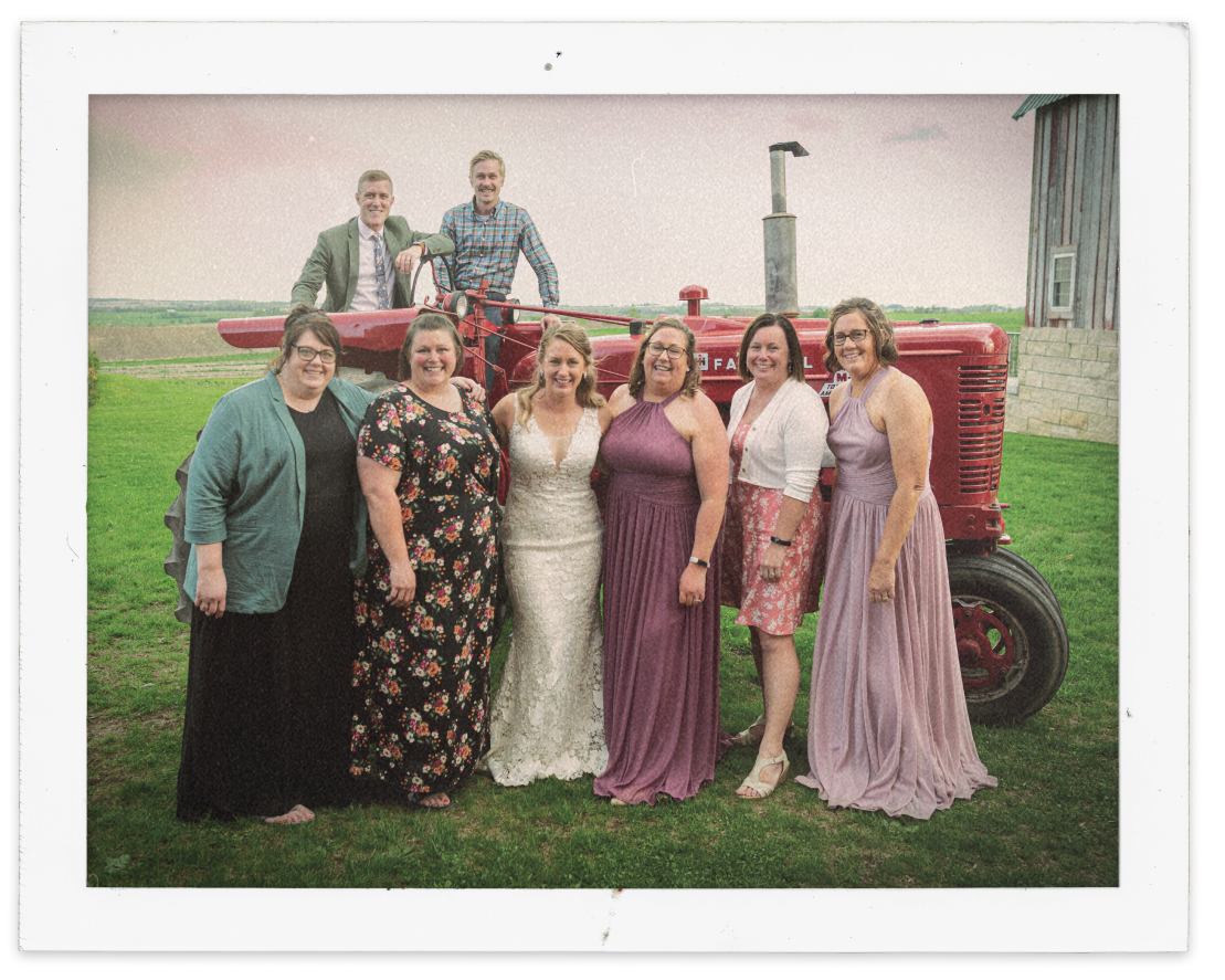 Holly with family and friends taking a picture in front of her Farmall M-TA