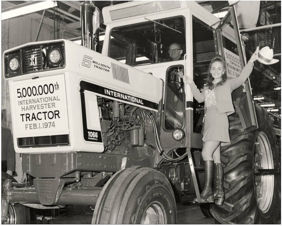 Black and white image of a man and woman celebrating the 5 millionth Farmall tractor to roll off the production line