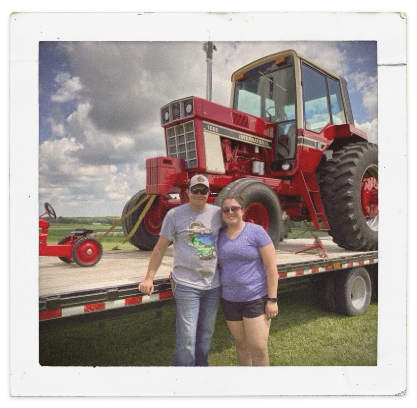 Sam and Raelynn taking a picure infront of their Farmall 1086